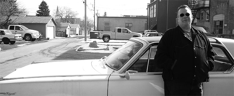 Fred Holliss in front of a Valiant car